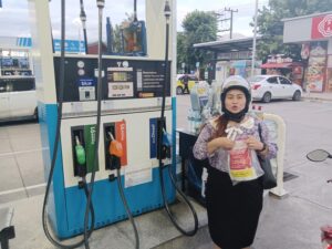 Jeje standing next to fuel pumps at a PTT station in Chiang Mai