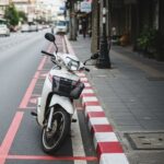 Scooter parked in a no parking zone, indicated by red and white curb